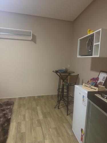 a room with a kitchen with a refrigerator and a table at Flat mobiliado centro formosa Go in Formosa