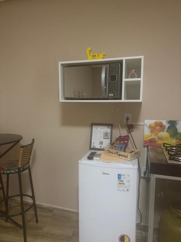 a small kitchen with a microwave and a refrigerator at Flat mobiliado centro formosa Go in Formosa