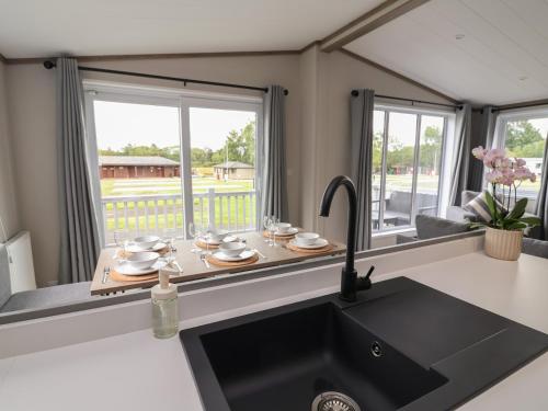 a kitchen with a sink and a counter top at Cedar Lodge 3 Bedrooms with hot tub in Northwich
