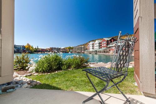 a metal chair sitting on the grass near the water at Willows #1704 in Keystone