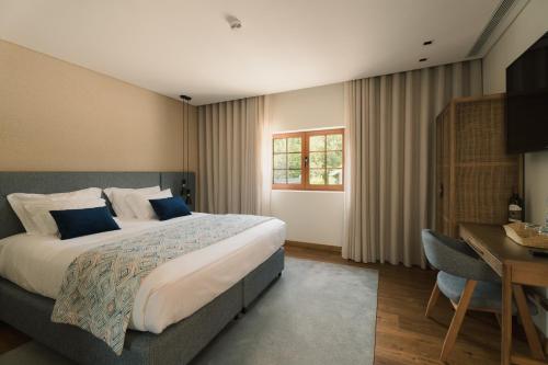 a hotel room with a large bed and a desk at Constance Retreat - Douro Verde by FERO in Constance