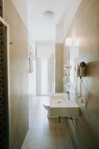a bathroom with a sink and a phone on the wall at Hotel Holiday in Vasto