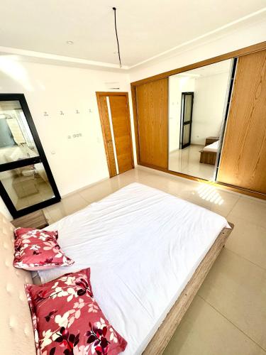a large bed in a room with a mirror at Pearl Beach Apartment in Monastir