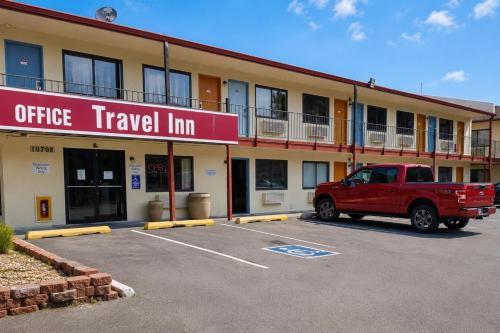 a red truck parked in a parking lot in front of an office travel inn at Travel Inn By OYO Omaha in Millard