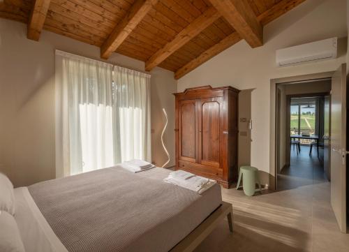a bedroom with a bed and a large window at Radici in Serralunga d'Alba