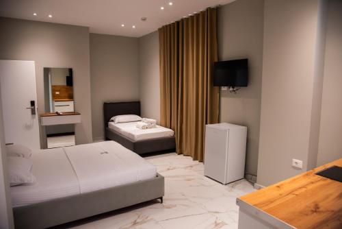 a hotel room with two beds and a television at Dine Residence in Himare