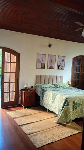 a bedroom with a bed and some pictures on the wall at Hospedaria Clã do Cla in Arraial do Cabo
