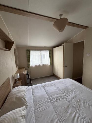 a bedroom with a large white bed and a window at Seaview Holiday Rentals - Etchingham in Chestfield