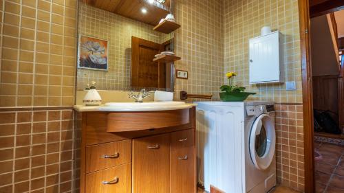 a bathroom with a sink and a washing machine at Casa Rue in Deltebre