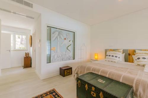 a bedroom with a large bed and a painting on the wall at Villa Lottus in Carvalhal