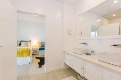 a white bathroom with a bed and a mirror at Villa Lottus in Carvalhal
