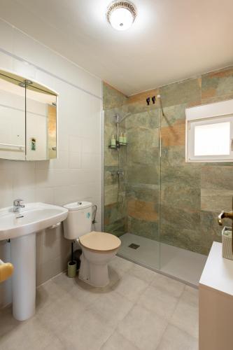 a bathroom with a toilet and a sink and a shower at Apartament in Monte Pedreguer in Pedreguer