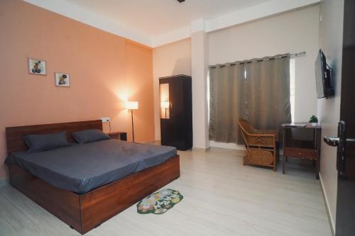a bedroom with a bed and a desk and a table at Mong Mao Manor in Guwahati