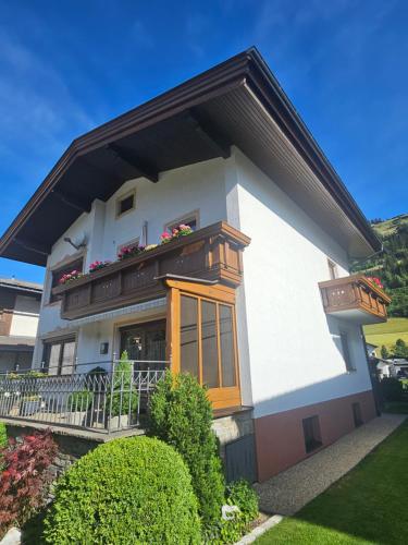 a large white house with a balcony and plants at Appartement Maria Leiter in Sillian