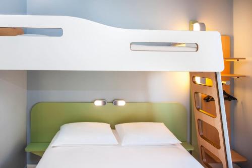 a bunk bed with two white beds in a room at Ibis Budget Mulhouse Centre Gare in Mulhouse
