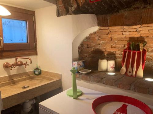 a kitchen with a sink and a brick wall at Il Nido di Ory in Clusane sul Lago