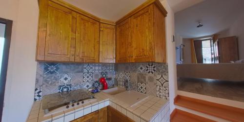 a kitchen with wooden cabinets and a sink at Borgo Tibetano in Castelsaraceno