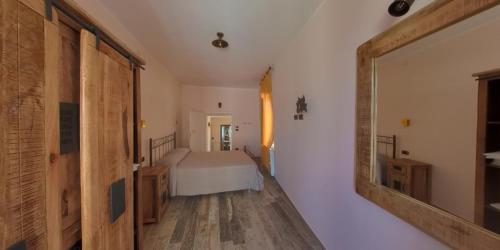 a bedroom with a bed and a large mirror at Borgo Tibetano in Castelsaraceno