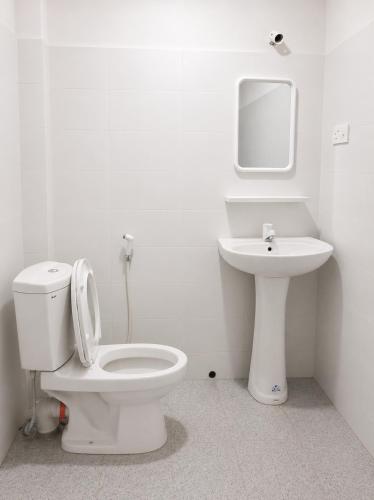 a white bathroom with a toilet and a sink at Villa Ocean Gift in Galle