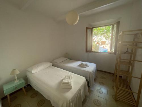 two beds in a room with a window at Via della Campana 17 in Portoferraio