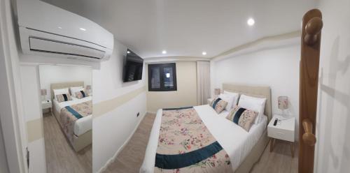 a small bedroom with two beds and a tv at Casa Sobreira de Mondim in Mondim de Basto