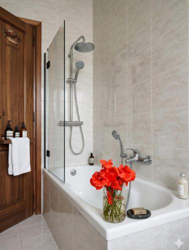 a bathroom with a bath tub with red flowers in a vase at Simohouse Lecce - Executive Suite Apartment 140mq - 2 Bathrooms in Lecce
