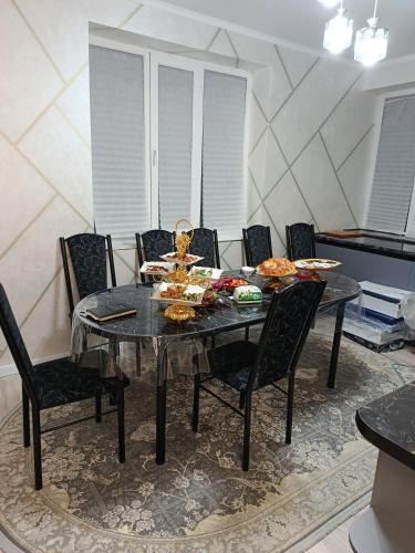 a dining room with a table and chairs with food on it at Sherine house in Tamga