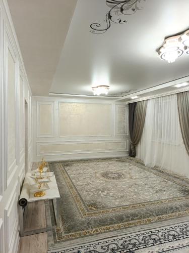 a white room with a table and a rug at Sherine house in Tamga