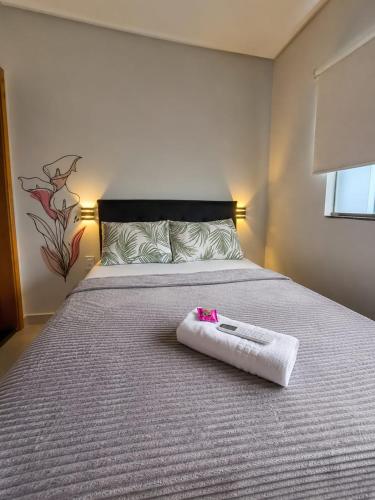 ein weißes Handtuch auf einem Bett in einem Zimmer in der Unterkunft Flat AR Moderno com Ar Condicionado e Estacionamento in Rio Claro