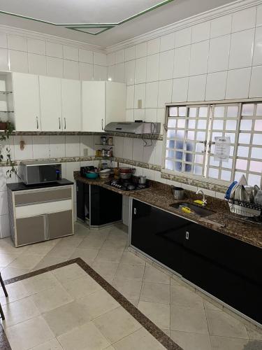a kitchen with white cabinets and a counter top at Quarto individual Quarto 2 in Montes Claros