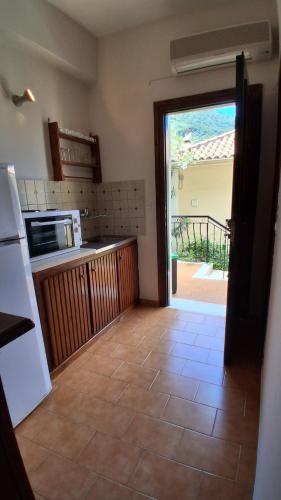 a kitchen with a door leading to a patio at Castello Bellos studios in Marathias