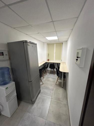 a kitchen with a refrigerator and a table with chairs at Хостел Мануфактура in Kharkiv