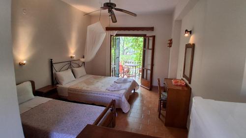 a bedroom with two beds and a door to a patio at Castello Bellos studios in Marathias