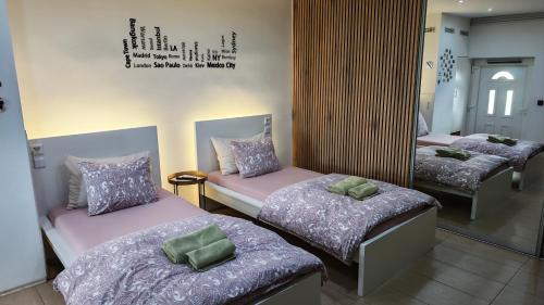 a room with three beds and a mirror at Apartman i Studio apartman Majoli in Kukuljanovo
