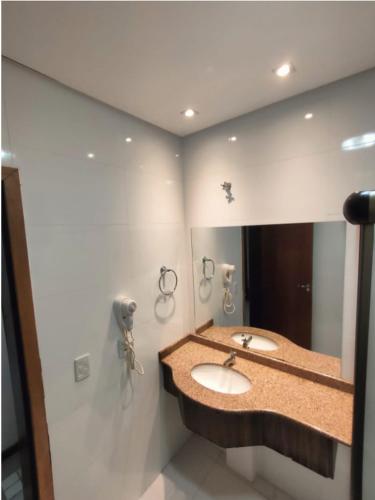 a bathroom with two sinks and a large mirror at GoldMen Business Sorriso in Sorriso