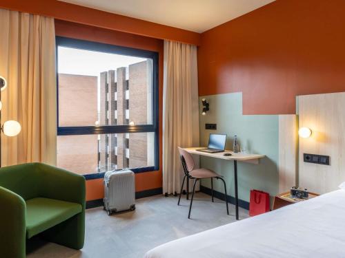 ein Hotelzimmer mit Bett, Schreibtisch und Fenster in der Unterkunft Ibis Styles Zaragoza Centro in Saragossa
