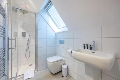 a bathroom with a sink and a toilet and a shower at RA7C Stylish Loft Stay in Batley