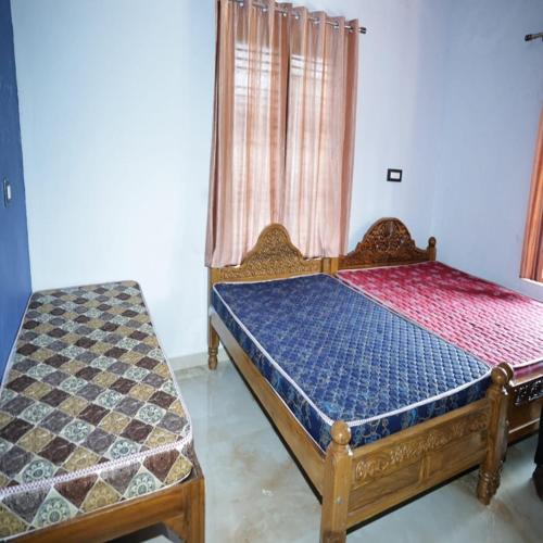a bedroom with a wooden bed and a window at Sindu Homestay in Kalasa