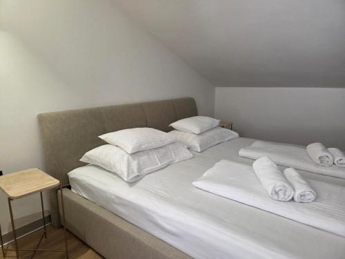 a bed with white pillows and towels on it at SmartStay Johnny in Podstrana