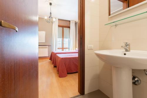 a bathroom with a sink and a bed in a room at Affittacamere Pizzeria Ristorante Treppì in Caldiero