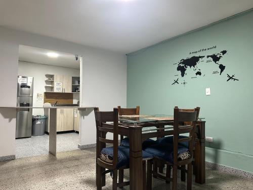 a kitchen with a table and chairs with a world map on the wall at Habita Coliving La Palma in Medellín