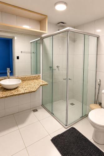 a bathroom with a glass shower and a toilet at Condomínio Harmonia in Pipa