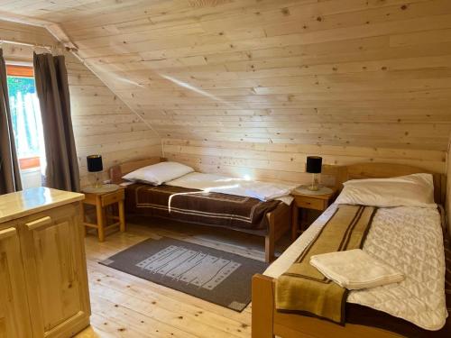 a room with two beds in a log cabin at Brvnarica na reci in Brus