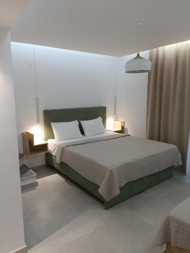 a bedroom with a large bed with two lamps at Gatos Beach in Pefkochori