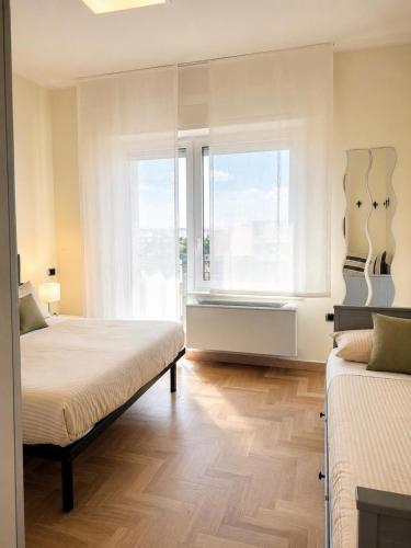 a bedroom with two beds and a window at Maison Belle Vue in Chioggia