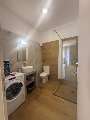a bathroom with a washing machine and a toilet at Elements Villas in Paleros