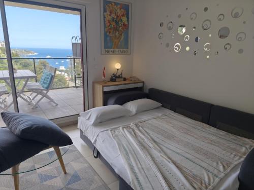 a bedroom with a bed and a balcony with a table at Beautiful Sea View Home Overlooking Monaco in Beausoleil