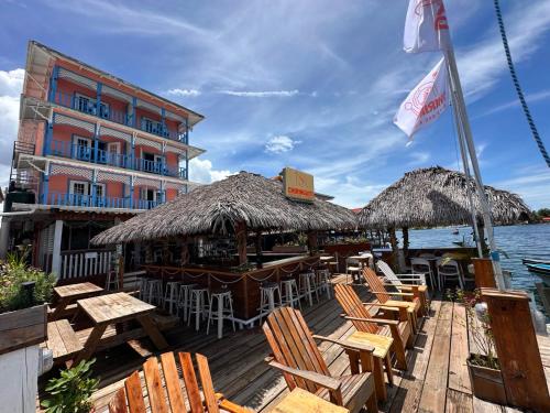 a wooden deck with chairs and tables and a building at Hotel Bocas Town in Bocas Town