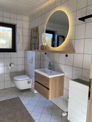 a bathroom with a sink and a toilet and a mirror at Casa Piedra in Kleinsteinhausen