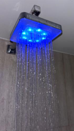 a blue shower head with water hanging from it at Private Hydro Spa Pool, Dbl Bedrm & Bathrm - Other areas part private shared lived-in home in Bickershaw
